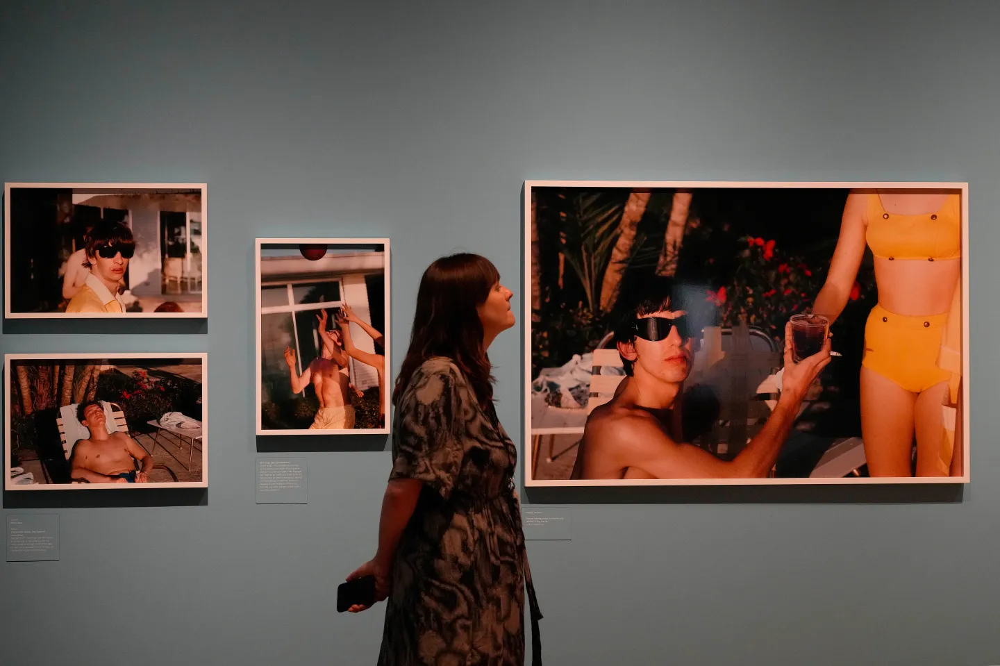 A woman strolls in an art gallery.